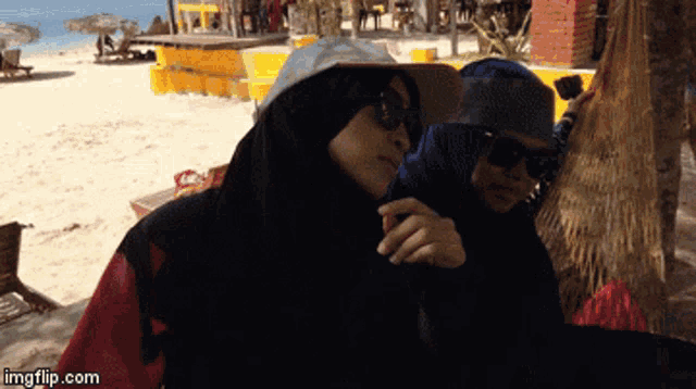 a couple of women standing on a beach with imgflip.com at the bottom of the screen