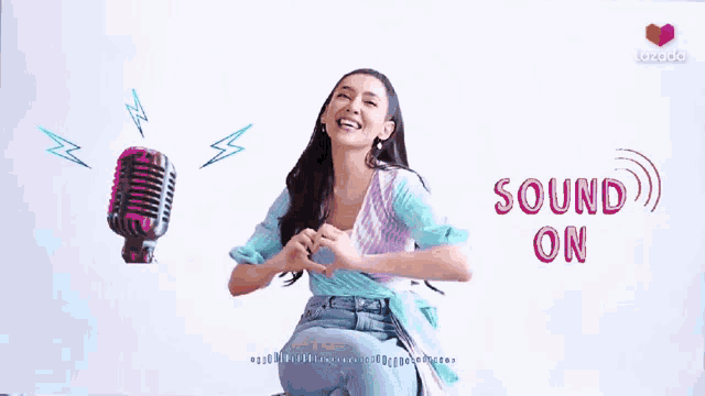 a woman is making a heart shape with her hands in front of a microphone that says " sound on "