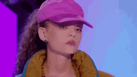 a close up of a woman wearing a pink hat and a yellow jacket .