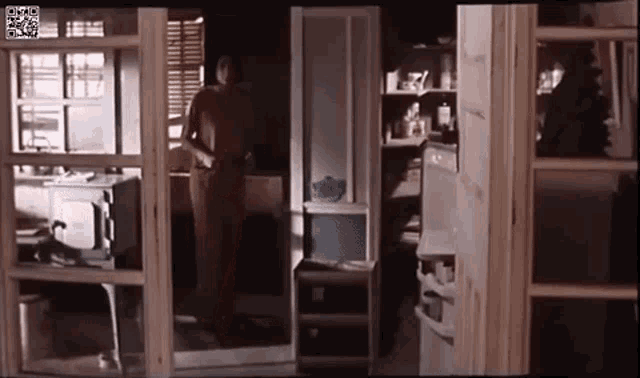 a man is standing in a room with a sliding glass door .