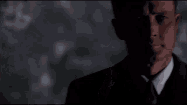 a man in a suit and tie is in the dark