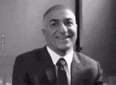 a man in a suit and tie is smiling in a black and white photo with the hashtag @ingitbot