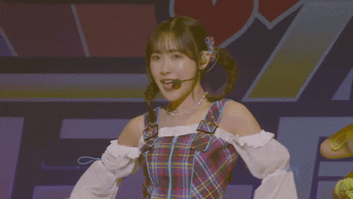 a girl with pigtails is wearing a plaid dress