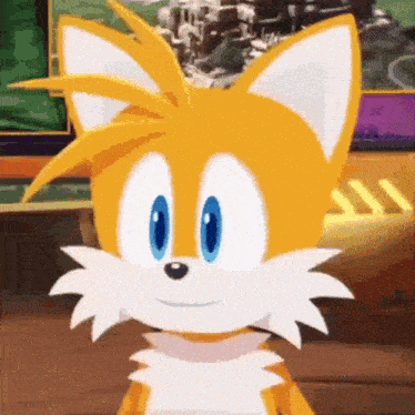 tails from sonic the hedgehog is smiling and looking at the camera while standing on a wooden floor .