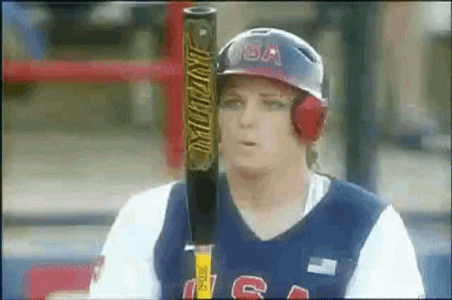 a baseball player wearing a helmet and headphones is holding a bat ..