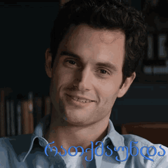 a man in a blue shirt is smiling in front of a sign that says " georgia "