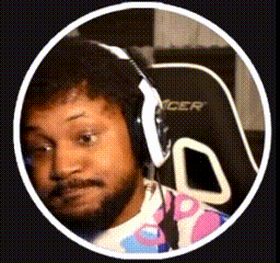 a man with a beard is wearing headphones and sitting in a gaming chair .