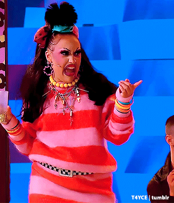 a woman in a pink and red striped sweater is making a face