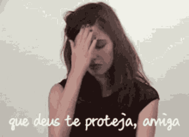 a woman is covering her face with her hand and the words que deus te proteja amiga are below her