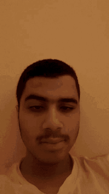 a close up of a man 's face against a yellow wall