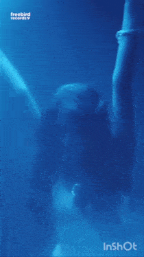 a woman is standing in a blue room with a freebird records logo