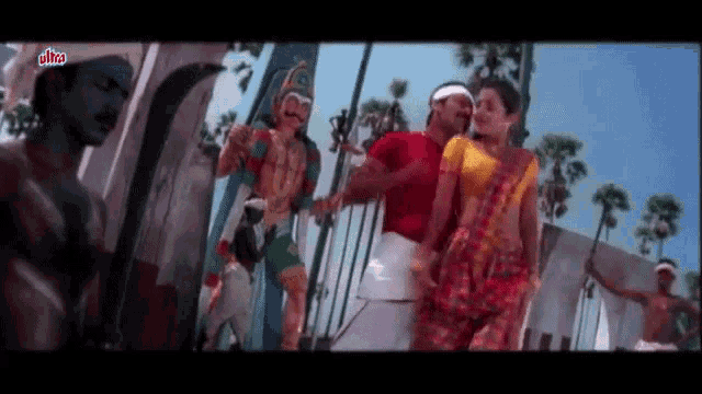 a man and a woman are dancing in front of a statue of a snake .