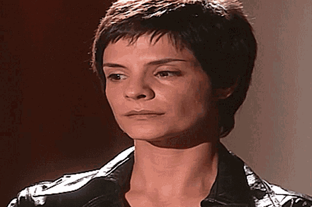 a woman with short hair is looking at the camera