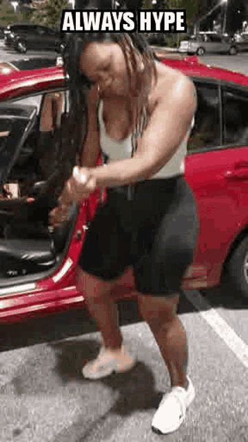 a woman is standing in front of a red car .
