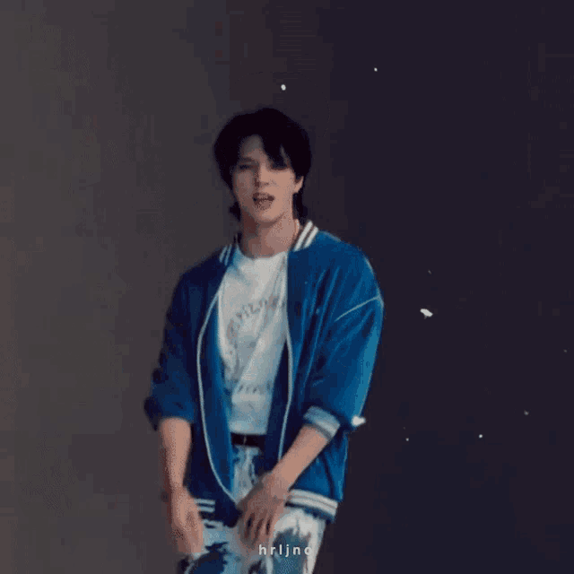 a man wearing a blue jacket and a white t-shirt with a circle on it