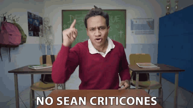a man sitting at a desk in a classroom with the words no sean criticones written on the desk