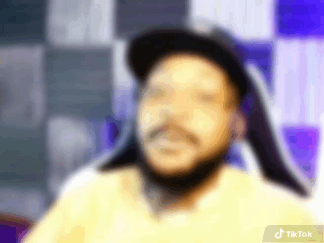 a blurry picture of a man 's face with a tiktok logo in the bottom right