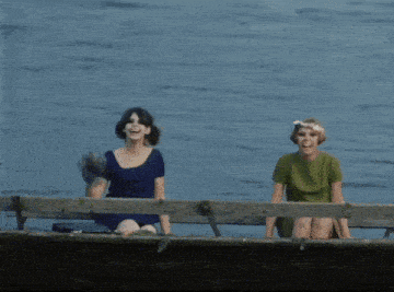 two women are sitting in a boat on the water