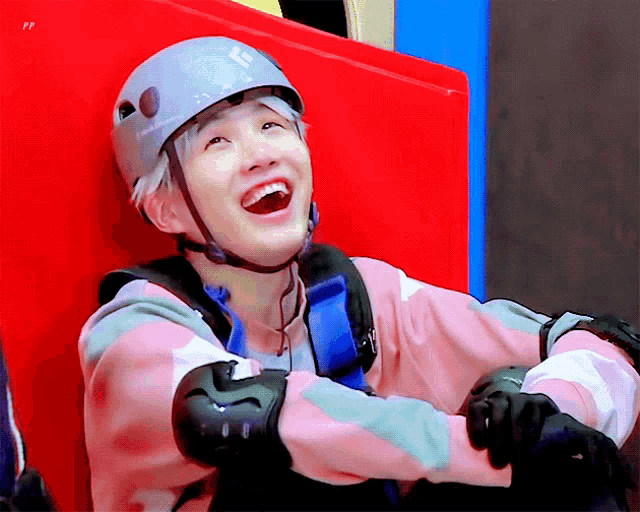 a person wearing a helmet and knee pads laughs