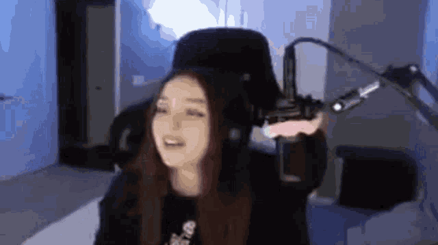 a girl is sitting in front of a microphone in a room .