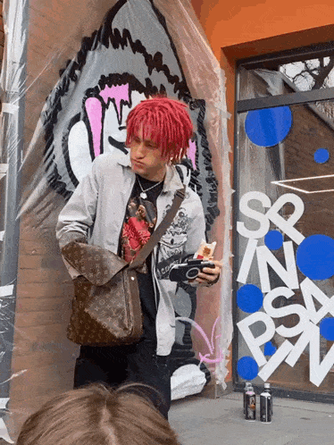a man with red hair stands in front of a sign that says sr n psa