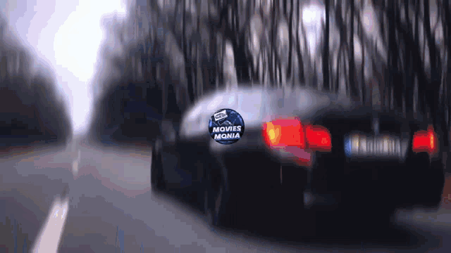 a car driving down a road with a sticker that says movies mania