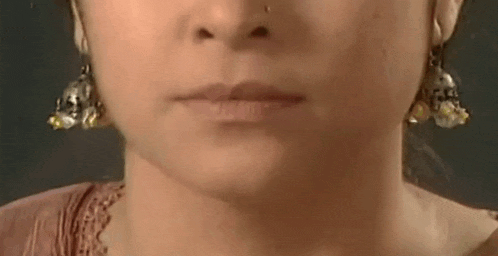 a close up of a woman 's face with earrings .