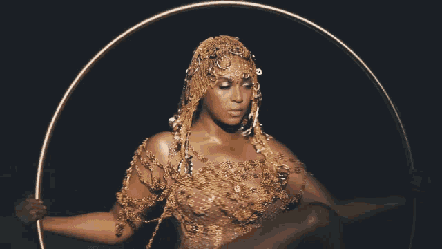 a woman in a gold outfit is sitting in a circle