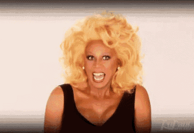 a drag queen with blonde hair and a black tank top is making a funny face .