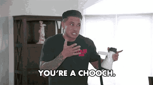 a man in a black shirt is holding a vacuum cleaner and says you 're a chooch