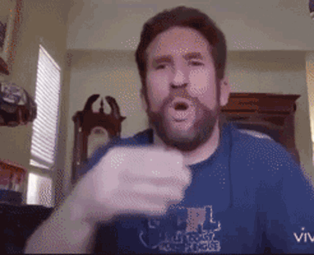 a man with a beard is wearing a blue shirt that says ' vive ' on the sleeve