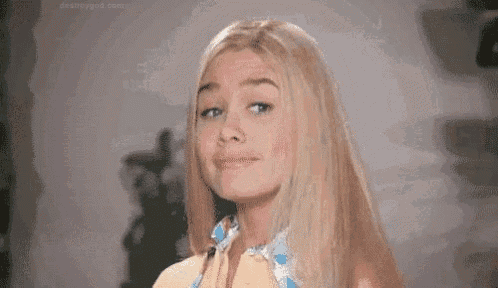 a blonde woman with long hair is making a funny face .