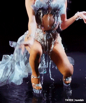 a woman in a silver dress is dancing in the water