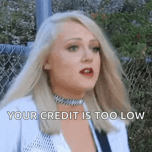 a woman with blonde hair is standing in front of a chain link fence .