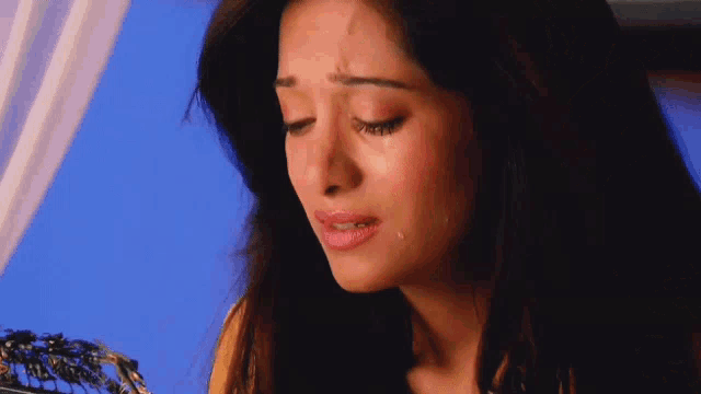 a close up of a woman 's face with tears coming out of her eyes