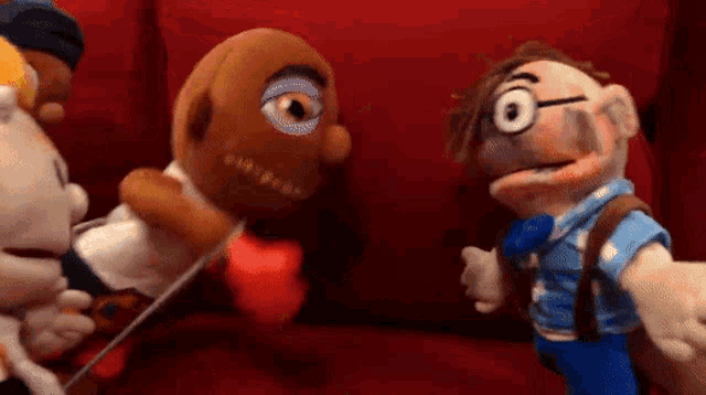 a group of stuffed animals are sitting on a red couch