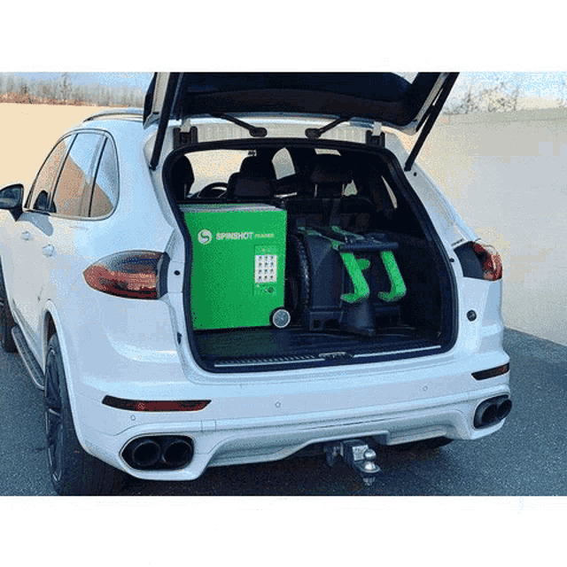 the back of a white car with a green machine in the back .