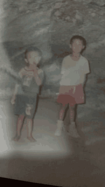 two young boys standing next to each other with one wearing a shirt that says ' a ' on it