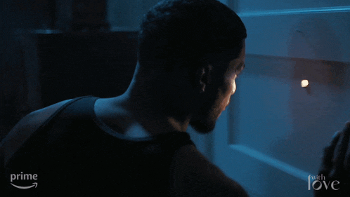 a man is looking through a door with the word love on the bottom right