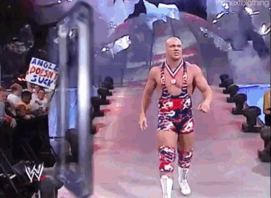 a wrestler is walking down the ring with a sign that says angle does n't suck