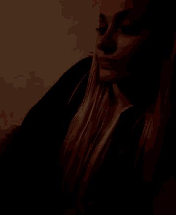 a woman 's face is visible in a dark room