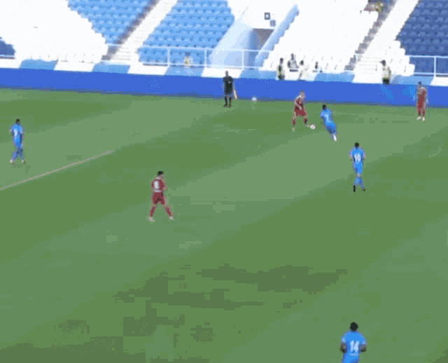 a group of soccer players are playing on a field with a stadium in the background
