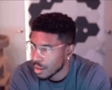 a man wearing glasses and a beard is looking at the camera .