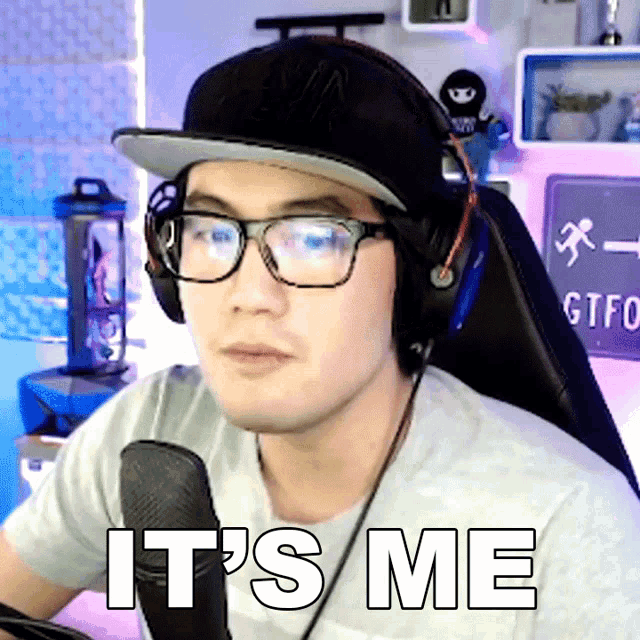 a man wearing glasses and headphones says " it 's me "