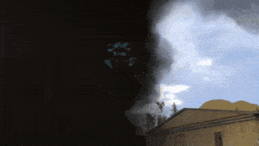 a building with smoke coming out of it and a cloudy sky in the background