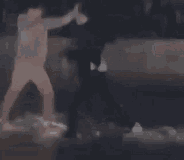 a blurry picture of two men standing next to each other in a room .