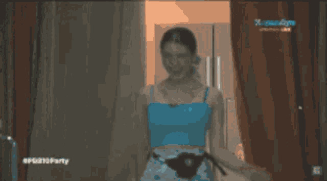 a woman in a blue top is standing in front of a door with the word party on the bottom