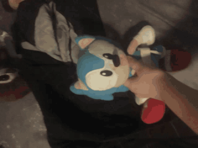 a person holding a stuffed sonic the hedgehog