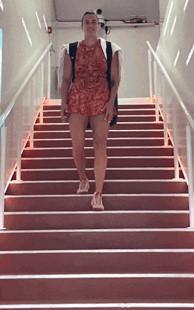 a woman in a red dress is walking up a set of red stairs