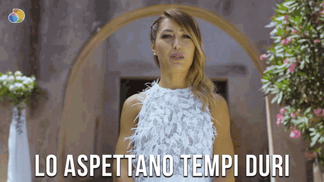 a woman in a white dress with the words lo aspettano tempi duri written below her